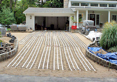 Heated driveway with pavers being installed.