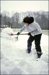 Shoveling snow from a driveway after a snowstorm.