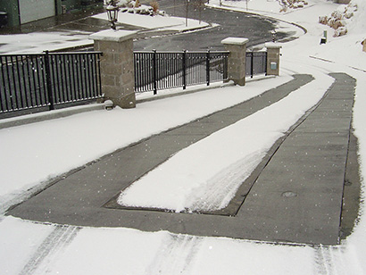 Heated concrete driveway with heated tire tracks.